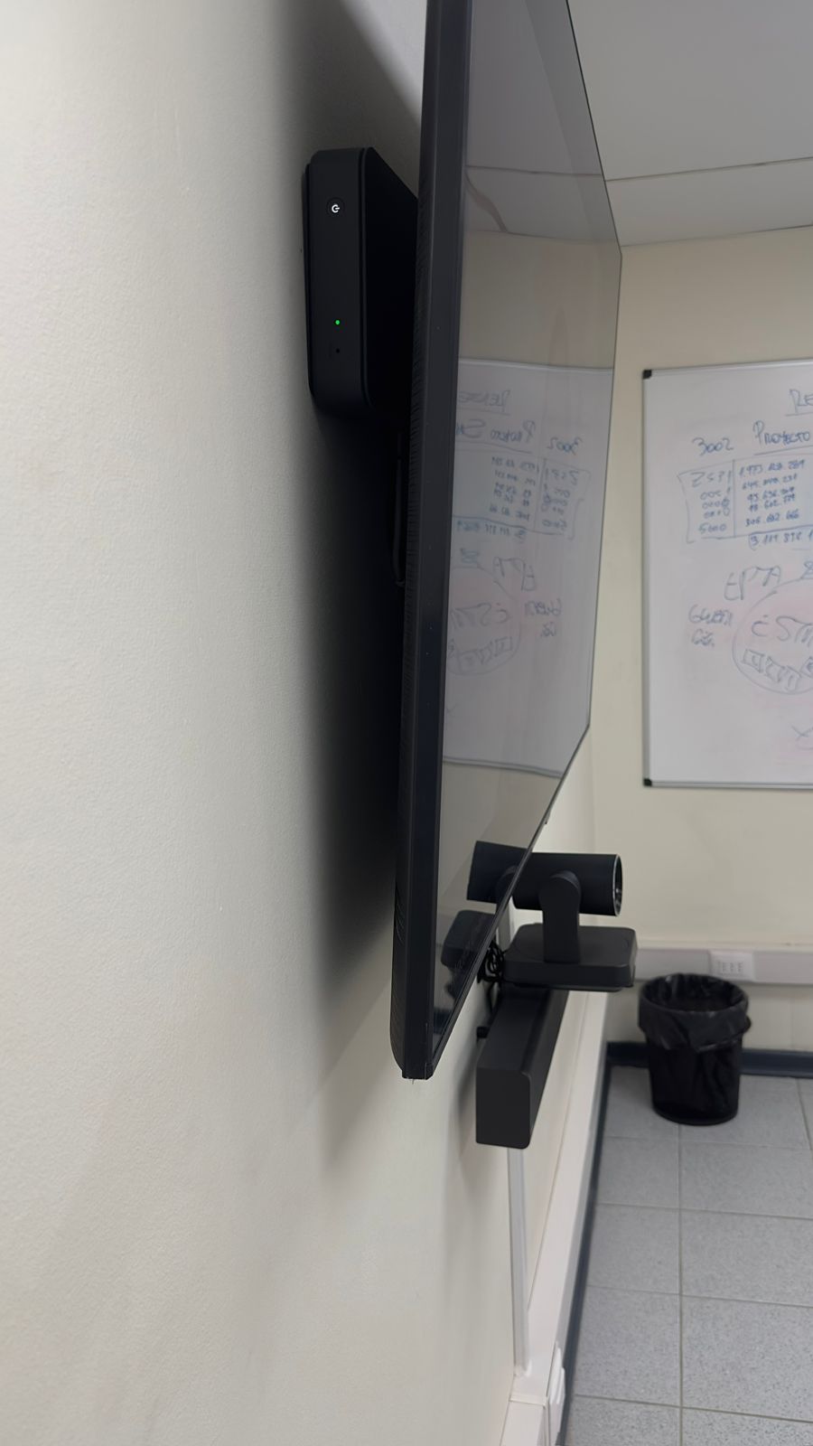 Sala de reuniones equipada con pantalla, cámara PTZ y panel táctil